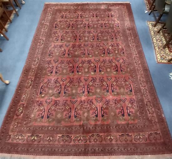 An Afghan red ground carpet 340 x 240cm